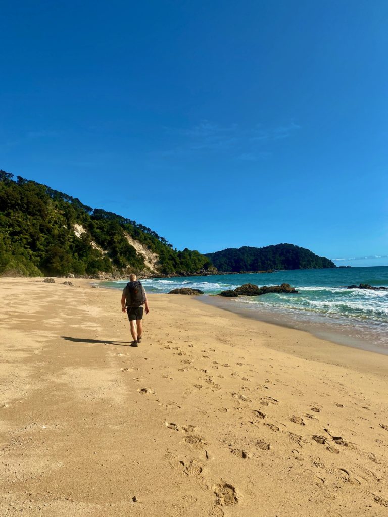 Man hiking on beach as green exercise