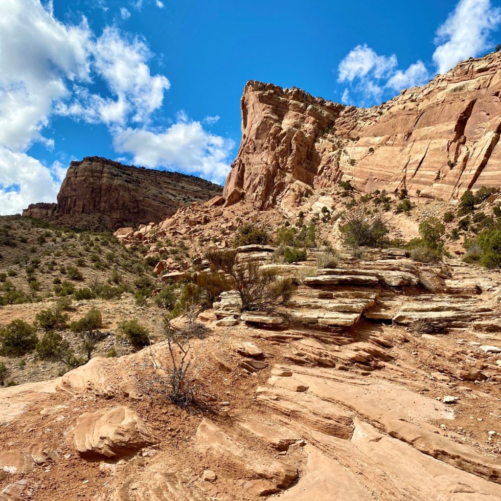 Hiking Colorado National Monument ascent with rock wall